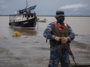 A Navy soldier stands guard as authorities wait for the arrival of people who were evacuated from the Monkey Point community, at the port in Bluefields, Nicaragua, Friday, July 1, 2022. Bonnie has formed over the Caribbean as it heads for a quick march across Central America and potential development into a hurricane after reemerging in the Pacific.