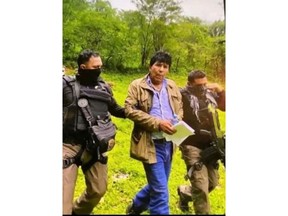 In this government handout photo provided by Mexico's Secretariat of the Navy, agents escort drug trafficker Rafael Caro Quintero, in Sinaloa state, Mexico, Friday, July 15, 2022, captured deep in the mountains of his home state. It was a 6-year-old bloodhound named "Max" who rousted Caro Quintero from the undergrowth. (Mexico's Secretariat of the Navy via AP)