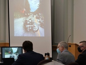 Volodymr Zhukovskyy, of West Springfield, Mass., right, is seated with defense attorneys Jay Duguay, left, and Steve Mirkin, center, as an image from the scene of a 2019 crash is projected on a screen, behind, during Zhukovskyy's trial at Coos County Superior Court, in Lancaster, N.H., Tuesday, July 26, 2022. Zhukovskyy has pleaded not guilty to multiple counts of negligent homicide, manslaughter, reckless conduct and driving under the influence in the June 21, 2019, crash.