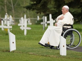 Pope Francis prays at a gravesite at the Ermineskin Cree Nation Cemetery in Maskwacis, Alta., during his papal visit across Canada on Monday, July 25, 2022. Pope Francis delivered a historic apology to survivors of the country's residential school system, the majority of which were operated by the Catholic Church.