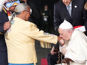 Pope Francis kisses the hand of residential school survivor Alma Desjarlais of the Frog Lake First Nation as Chief Greg Desjarlais (left) looks on as he arrives in Edmonton on Sunday, July 24, 2022. His visit to Canada is aimed at reconciliation with Indigenous people for the Catholic Church's role in residential schools.THE CANADIAN PRESS/Nathan Denette
