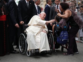 Pope Francis greets Evangelista Herrera (in wheelchair) as he arrives at the Cathedral-Basilica of Notre-Dame de Quebec in Quebec City to preside over an evening prayer service during his papal visit across Canada on Thursday, July 28, 2022.
