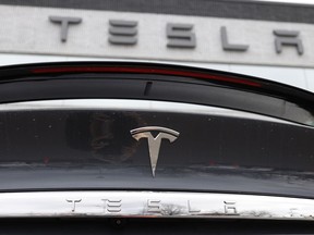 FILE - In this April 26, 2020 photo, the company logo shines off the rear deck of an unsold 2020 Model X at a Tesla dealership in Littleton, Colo. Tesla's sales from April through June 2022 fell to their lowest quarterly level since last fall as supply chain issues and pandemic restrictions in China hobbled production of its electric vehicles.