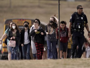 FILE - Students from Olathe East High School are lead to a staging area to reunite with their parents after a shooting at the school in Olathe, Kan., on March 4, 2022. A school resource officer who shot and wounded a Kansas high school student during a confrontation in March believed his life was in danger and will not face charges, a prosecutor announced Friday, July 22, 2022.
