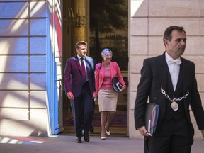 French President Emmanuel Macron and Prime Minister Elisabeth Borne arrive to attend the first cabinet meeting with new ministers at the Elysee Palace in Paris, Monday, July 4, 2022. French President Emmanuel Macron rearranged his Cabinet on Monday in an attempt to adjust to a new political reality following legislative elections in which his centrist alliance failed to win a majority in the parliament.