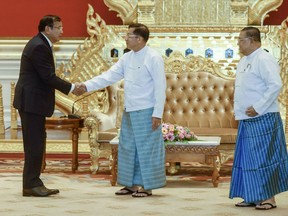 In this photo provided by the Myanmar's Foreign Ministry, Myanmar State Administration Council Chairman Senior General Min Aung Hlaing, center, shakes hands with Cambodian Foreign Minister and ASEAN Special Envoy to Myanmar Prak Sokhonn, left, and Myanmar Foreign Minister Wunna Maung Lwin, right, during a meeting in Naypyitaw, Myanmar, Thursday, June 30, 2022. (Myanmar's Foreign Ministry via AP)