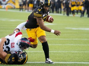 Hamilton Tiger Cats quarterback Jamie Newman (14) carries into the end zone for a touchdown against Montreal Alouettes during first half CFL football game action in Hamilton, Ont. on Thursday, July 28, 2022.