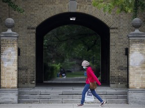 A woman walks on the University of Toronto campus in Toronto, Tuesday, Sept. 8, 2020. Students and staff planning to live in University of Toronto residences will need to have two shots of a COVID-19 vaccine and at least one booster dose before moving in this September.THE CANADIAN PRESS/Cole Burston