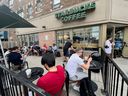 People crowd around a Starbucks coffee shop to use its free wifi on the Bell network, during a major outage of Rogers Communications mobile and internet networks in Toronto, July 8, 2022. 