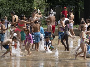 People cool off at a splash pad as temperatures go above 30 celsius Wednesday, July 20, 2022 in Montreal.