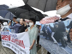 Members of North Korean human rights stage a rally to denounce South Korea's deportation of two North Korean fishermen in 2019, in front of the National Assembly in Seoul, South Korea, Wednesday, July 13, 2022. South Korean prosecutors raided the country's main spy agency Wednesday as part of investigations into two past North Korea-related incidents that drew criticism that the previous liberal government ignored basic principles of human rights to improve ties with Pyongyang.