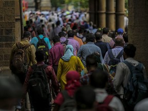 Commuters exit the Chhatrapati Shivaji Maharaj Terminus (CST) railway station in Mumbai, India, on Monday, July 6, 2020.