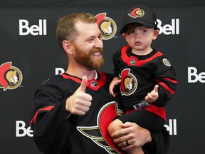Veteran forward Claude Giroux holds his son Gavin, 3, after pulling on an Ottawa Senators sweater in Ottawa on Wednesday, July 13, 2022. Giroux signed a 3-year contract with the team as free agency opened.