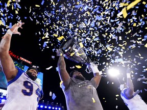 Winnipeg Blue Bombers offensive lineman Stanley Bryant (66) hoists the trophy with defensive end Jackson Jeffcoat (94) as they celebrate defeating the Hamilton Tiger-Cats in the 108th CFL Grey Cup in Hamilton on Sunday, December 12, 2021.