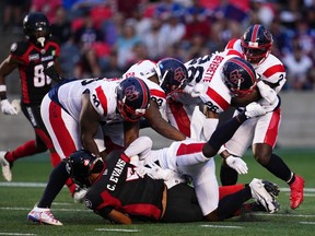 Five Montreal Alouettes players stop Ottawa Redblacks quarterback Caleb Evans (5) during first half CFL action in Ottawa on Thursday, July 21, 2022.