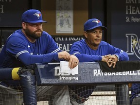 Toronto Blue Jays coach John Schneider, left, and manager Charlie Montoyo watch from the dugout during the eighth inning of a baseball game against the Tampa Bay Rays, Saturday, July 10, 2021, in St. Petersburg, Fla.