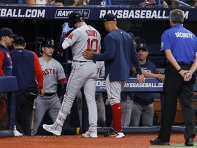 Boston Red Sox manager Alex Cora, right, walks the Red Sox's Trevor Story off the field against the Tampa Bay Rays during the fifth inning of a baseball game Tuesday July 12, 2022, in St. Petersburg, Fla.