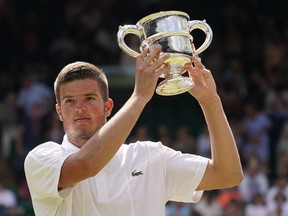 Croatia's Mili Poljicak holds the trophy as he celebrates after beating Michael Zheng of the United States to win the final of the boys' singles on day fourteen of the Wimbledon tennis championships in London, Sunday, July 10, 2022.