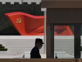 FILE - A security guard stands near a sculpture of the Chinese Communist Party flag at the Museum of the Communist Party of China on May 26, 2022, in Beijing. China said it was conducting military exercises Saturday, July 30, off its coast opposite Taiwan after warning Speaker Nancy Pelosi of the U.S. House of Representatives to scrap possible plans to visit the island democracy, which Beijing claims as part of its territory.
