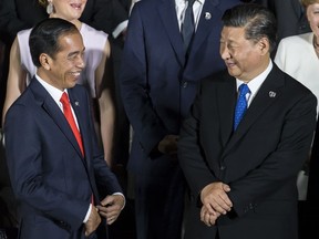 FILE - Indonesia's President Joko Widodo, left, speaks to China's President Xi Jinping during a family photo session in front of Osaka Castle at the G-20 summit, on June 28, 2019, in Osaka, Japan. President Widodo was heading to Beijing on Monday, July 24, 2022, for a rare visit by a foreign leader under China's strict COVID-19 protocols and ahead of what could be the first overseas trip by Chinese President Xi since the start of the pandemic more than two years ago.