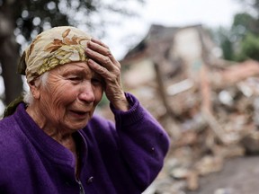Raisa Shapoval, 83, cries in front of the site of a military strike in Chuhuiv, about 6 km from the frontline, amid Russia’s invasion of Ukraine, in Kharkiv region.