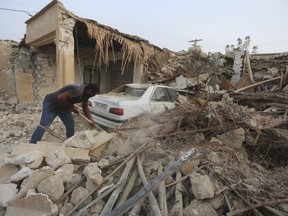 A man cleans up the rubble after an earthquake at Sayeh Khosh village in Hormozgan province, some 620 miles (1,000 kilometers) south of the capital, Tehran, Iran, Saturday, July 2, 2022.