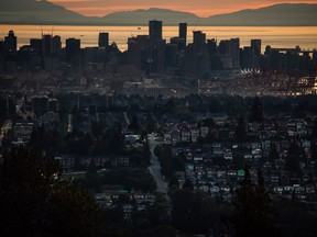 The downtown Vancouver skyline and port are seen at sunset along with houses lining a hillside in Burnaby, B.C., on Monday, July 11, 2022.