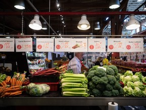 People shop for produce at the Granville Island Market in Vancouver, on Wednesday, July 20, 2022. As the cost of living rises at the fastest pace in decades, Canadians struggling to put food on the table are turning to community organizations for help.