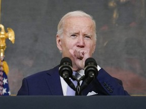 FILE - President Joe Biden coughs as he speaks about "The Inflation Reduction Act of 2022" in the State Dining Room of the White House in Washington, Thursday, July 28, 2022. Biden tested positive for COVID-19 again Saturday, July 30, slightly more than three days after he was cleared to exit coronavirus isolation, the White House said, in a rare case of "rebound" following treatment with an anti-viral drug.