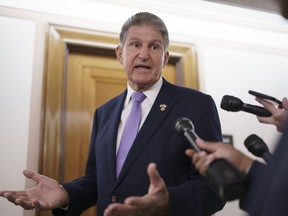 FILE - Sen. Joe Manchin, D-W.Va., is met by reporters outside the hearing room where he chairs the Senate Committee on Energy and Natural Resources, at the Capitol in Washington, July 21, 2022. Manchin has been an obstacle for Biden's climate change plans, a reflection of his outsized influence at a time when Democrats hold the narrowest of margins in the U.S. Senate.