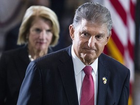 Sen. Joe Manchin, D-W.Va., and Sen. Shelley Moore Capito, R-W.Va., pay their respects as the flag-draped casket bearing the remains of Hershel W. "Woody" Williams, lies in honor in the U.S. Capitol, Thursday, July 14, 2022 in Washington. Manchin has told Senate Majority Leader Chuck Schumer that he will oppose a economic measure if it includes climate or energy provisions or boosts taxes on the rich or corporations.