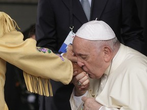 Pope Francis kisses hand to Canadian Indigenous woman as he arrives at Edmonton's International airport, Canada, Sunday, July 24, 2022. Pope Francis begins a weeklong trip to Canada on Sunday to apologize to Indigenous peoples for the abuses committed by Catholic missionaries in the country's notorious residential schools.
