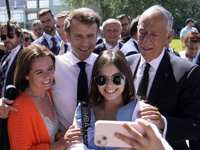French President Emmanuel Macron and his Portuguese counterpart Marcelo Rebelo de Sousa, right, pose for a photo with well-wishers outside the venue hosting the United Nations Ocean Conference in Lisbon, Thursday, June 30, 2022. From June 27 to July 1, the United Nations is holding its Oceans Conference in Lisbon expecting to bring fresh momentum for efforts to find an international agreement on protecting the world's oceans.