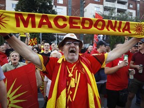 A protester dressed in the national colors attends a protest in front of the government building in Skopje, North Macedonia, on Saturday, July 2, 2022. Tens of thousands of people have gathered late on Saturday in North Macedonia's capital Skopje to protest the latest French presidency proposal on solving bilateral disputes with Bulgaria that gave directions for small Balkan country to open membership talks with the European Union.