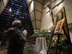 Faithful mourn in front of the photos of Jesuit priests Javier Campos Morales and Joaquin Cesar Mora Salazar during a Mass at a church in Mexico City, Tuesday, June 21, 2022. The two elderly priests were killed inside a church where a man pursued by gunmen apparently sought refuge in a remote mountainous area of northern Mexico, the religious order's Mexican branch announced Tuesday.