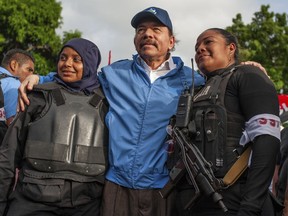 FILE - Nicaraguan police have their picture taken with President Daniel Ortega, in Masaya, Nicaragua, Friday, July 13, 2018. The government of the United States announced on Monday, June 13, 2022, that is restricting visas to members of the government of Nicaragua for having undermined democracy after the reelection of Ortega to the presidency.