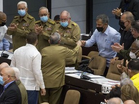 In this photo released by Cubadebate, Gen. Luis Alberto Rodriguez Lopez-Calleja, right, greets former Cuban President Raul Castro at the National Assembly in Havana, Cuba, Dec. 21, 2021. Lopez-Calleja, one of the most trusted advisers to Castro and head of the country's military business division, died on July 1, 2022 at age 62. The Communist Party and official news media said he died of a cardiopulmonary arrest.