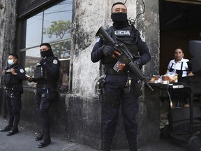 FILE - Heavily armed police guard the streets as part of a state of exception in downtown San Salvador, El Salvador, March 27, 2022. El Salvador's congress granted President Nayib Bukele late Tuesday, July 20, 2022 another 30-day extension of the state of exception that has suspended fundamental rights since a surge in gang killings in late March.