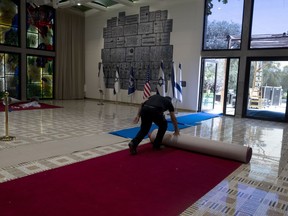 Ronen Sami unrolls red carpet to display for journalists ahead of a visit by U.S. President Joe Biden at the Israeli President's residence in Jerusalem, Monday, July 11, 2022. Biden visits Israel and the occupied West Bank this week for the first time since assuming office.