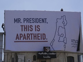 A billboard saying "Mr. President, this is apartheid" is posted by an Israeli human rights group in the West Bank town of Bethlehem ahead of the arrival of President Joe Biden in the region, Wednesday, July 13, 2022. The group B'Tselem put up the billboards in Ramallah, the seat of the internationally recognized Palestinian Authority, and in Bethlehem, where Biden is to meet Palestinian President Mahmoud Abbas on Friday.