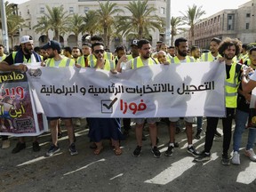 Protesters demonstrate in Martyrs Square in Tripoli, Libya, Friday, July 1, 2022, calling for election and protesting against the government and parliament. The banner reads, "Acceleration of the presidential and parliamentary elections, Immediately."