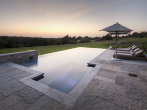 This custom infinity pool installed on a country estate in the Niagara Escarpment has a built-in hot tub feature.