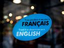 A bilingual sign hangs outside a shop in Montreal, Quebec, Canada. File: Brent Lewin/Bloomberg