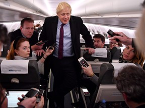 British Prime Minister Boris Johnson speaks with journalists aboard an Alsie Express flight to Birmingham in 2019. For some reason, the sight of a sitting Canadian prime minister aboard a WestJet or Air Canada flight is considered unthinkable.