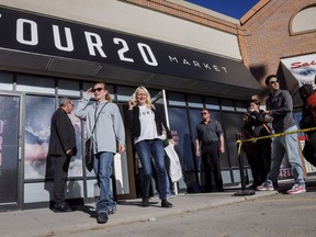 Customers leave a store after purchasing legal cannabis as other wait to get in the store in Calgary, Alta., Wednesday, Oct. 17, 2018.