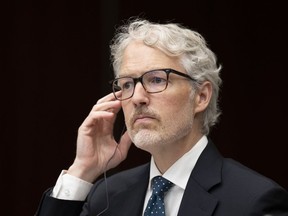 Privacy Commissioner of Canada Philippe Dufresne tests his translation aid as he waits to appear before the Standing Committee on Access to Information, Privacy and Ethics, Monday, August 8, 2022 in Ottawa.