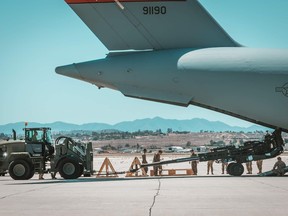 An M777 howitzer is loaded onto a U.S. Air Force Globemaster in June, destined for the Ukraine front lines. Canada has tacked on a few of its own M777s onto U.S. shipments, and arranged a deal to supply 20,000 shells for the guns.