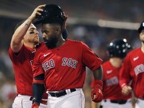 Boston Red Sox's Jackie Bradley Jr., centre, celebrates his two-run home run with Christian Vazquez, left, during the fourth inning of the team's baseball game against the Toronto Blue Jays in Boston, Friday, July 22, 2022. The Toronto Blue Jays have have signed the outfielder to a one-year major-league contract.