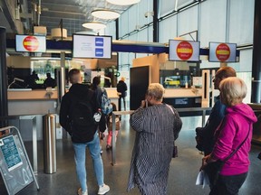 Russian tourists have their passport checked on July 28, 2022 at the Nuijamaa border crossing, Finland - At Nuijamaa border crossing in Lappeenranta, busses of Russian tourists stream into Finland, some looking to enjoy the peaceful Finnish summer and some planning to travel further into Europe.