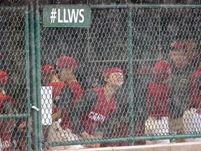 Vancouver, British Columbia, players wait in the dugout during a weather delay in their baseball game against Canada at the Little League World Series in South Williamsport, Pa., Wednesday, Aug. 17, 2022.
